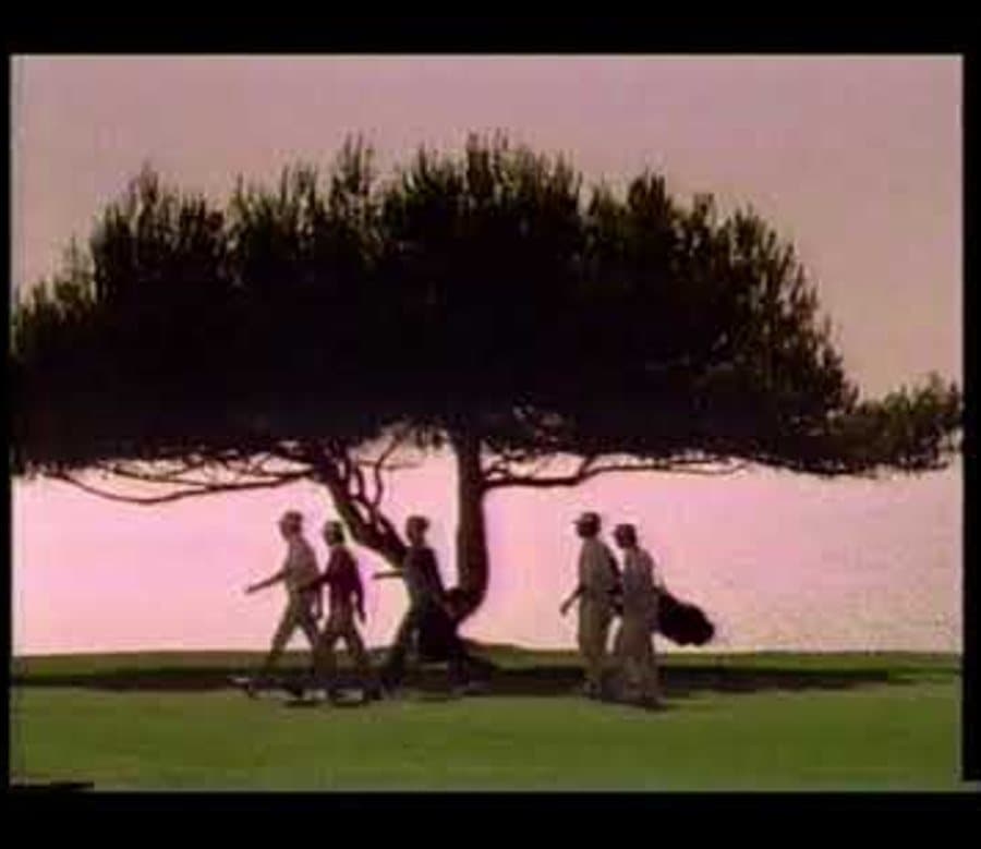 Still from the 1987 FootJoy commercial: golfers walking past a lone tree against a pink evening sky
